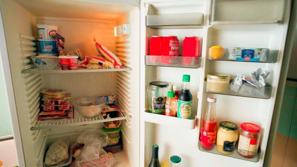 Open refrigerator filled with various food items and containers