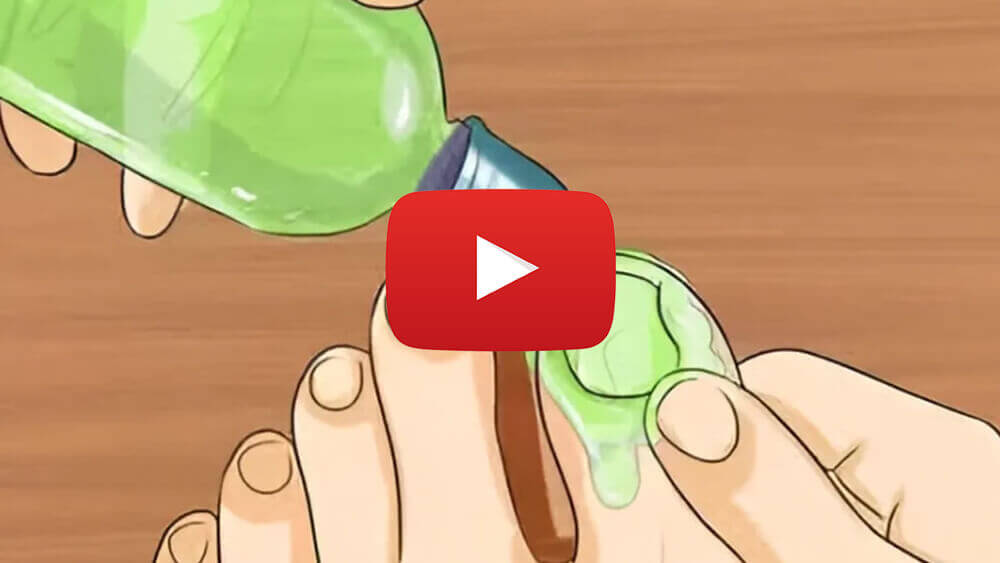 Hands applying green liquid to toenails